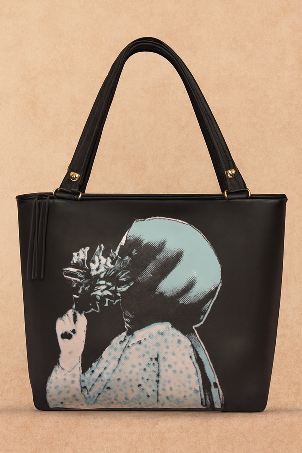 Black handbag with a printed design of a woman holding a flower on a beige background