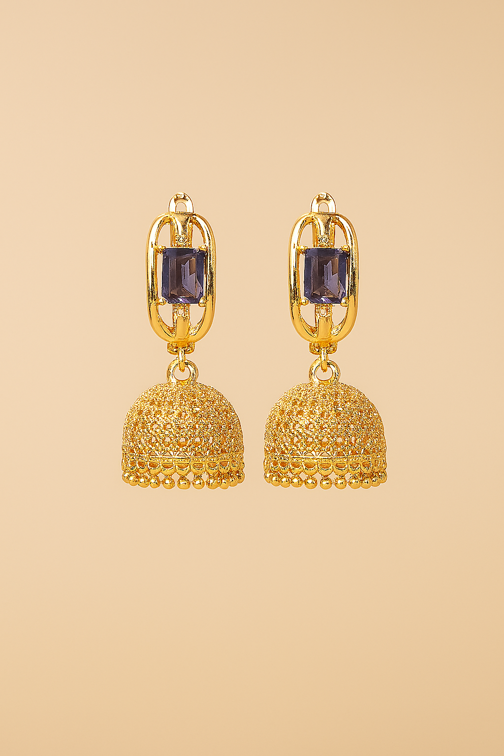 Gold earrings with purple gemstones on a beige background