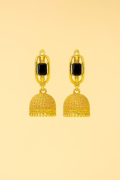 Gold earrings with black stones on a beige background