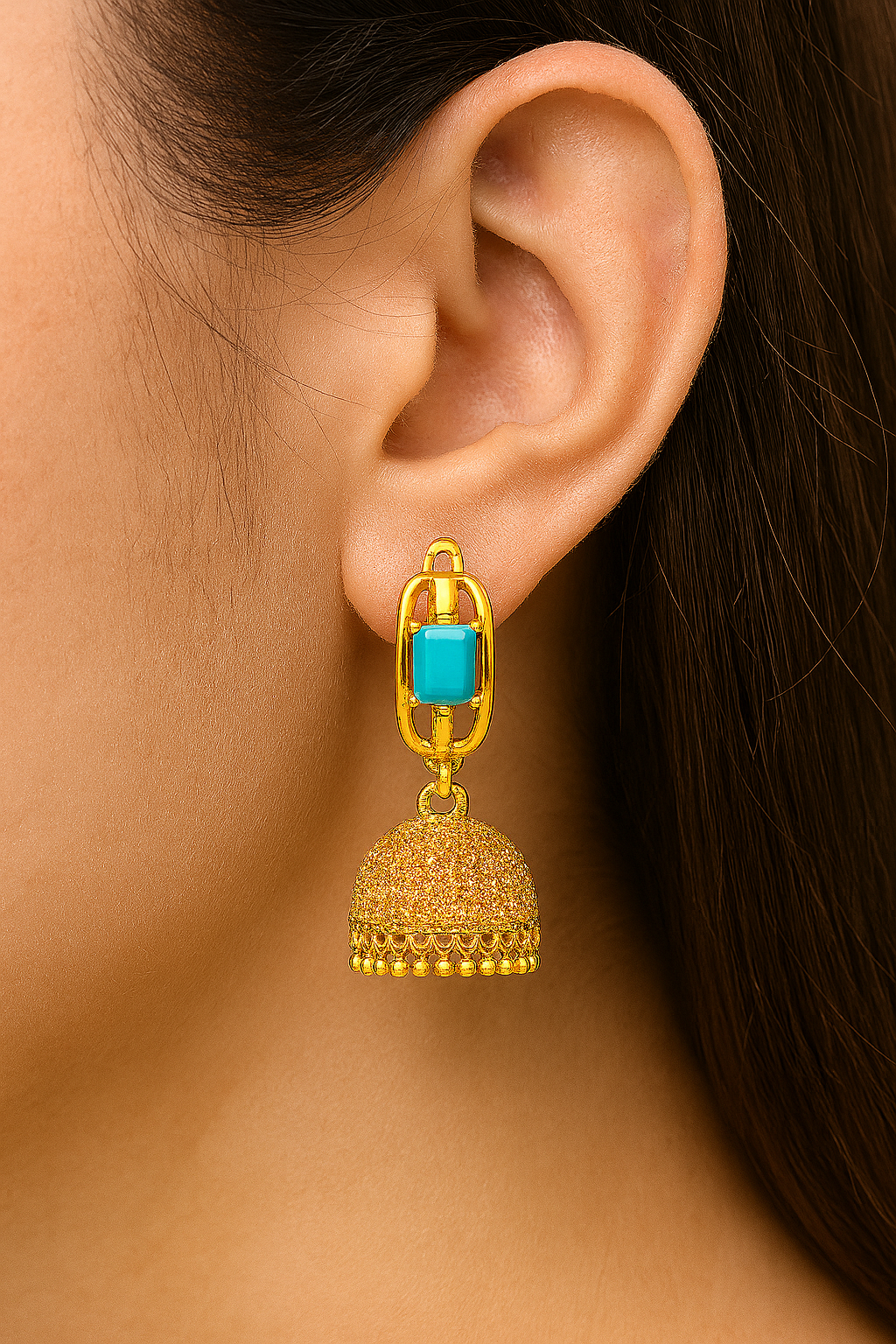 A pair of artificial gold-tone jhumka earrings with a turquoise-colored faux stone and dome-shaped danglers