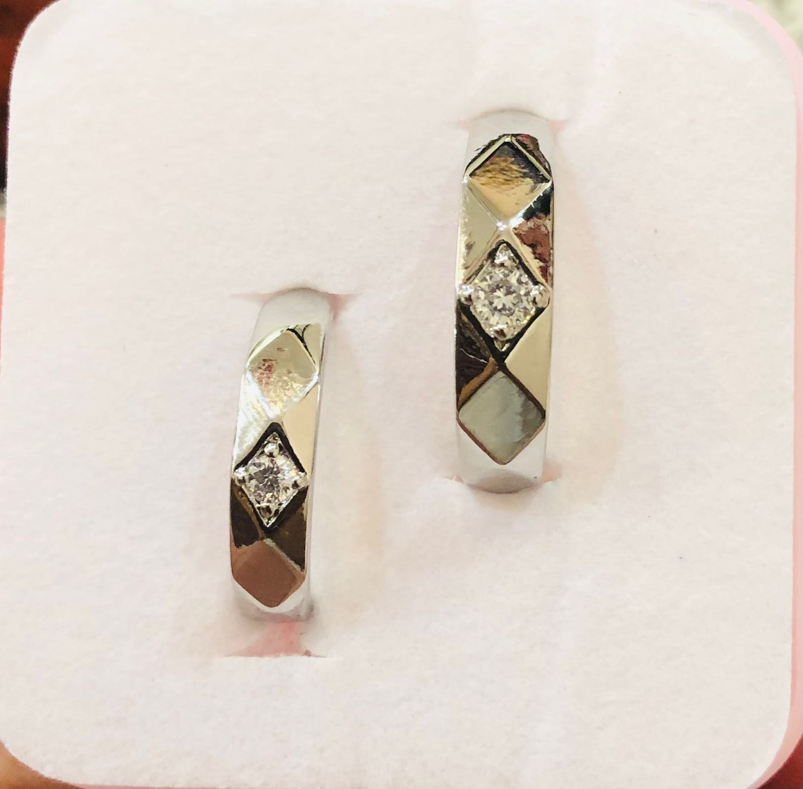 Pair of diamond-studded earrings on a white background