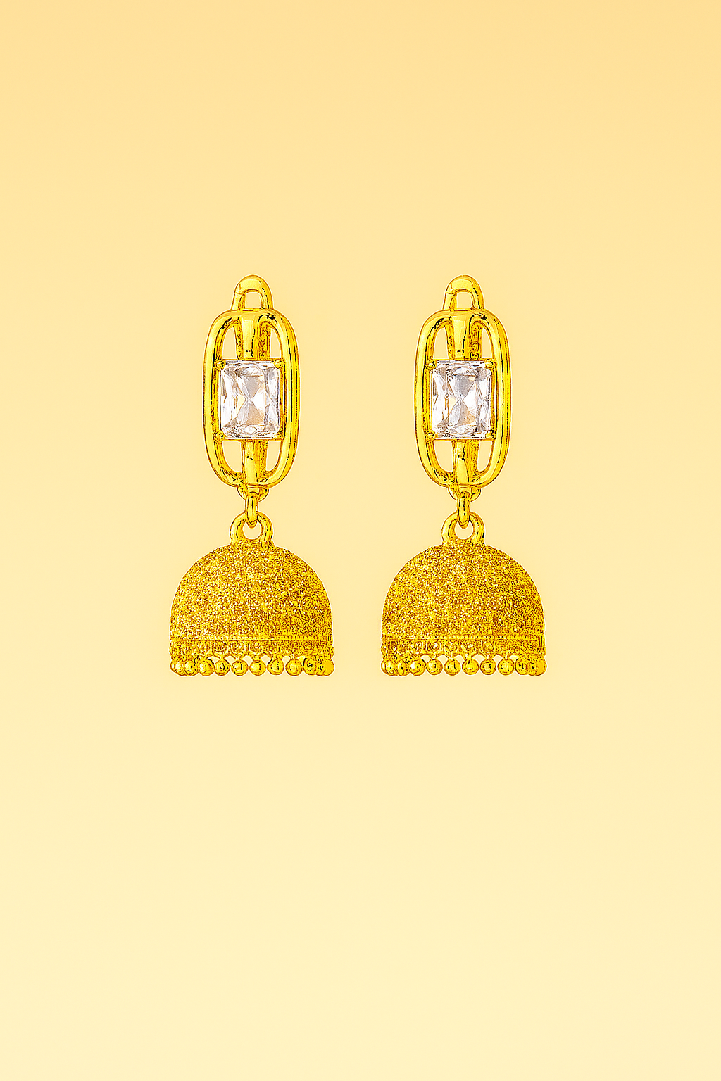 Gold earrings with gemstones on a yellow background