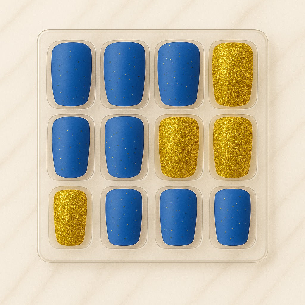 Set of blue and gold nail polish samples in a clear plastic tray on a beige background
